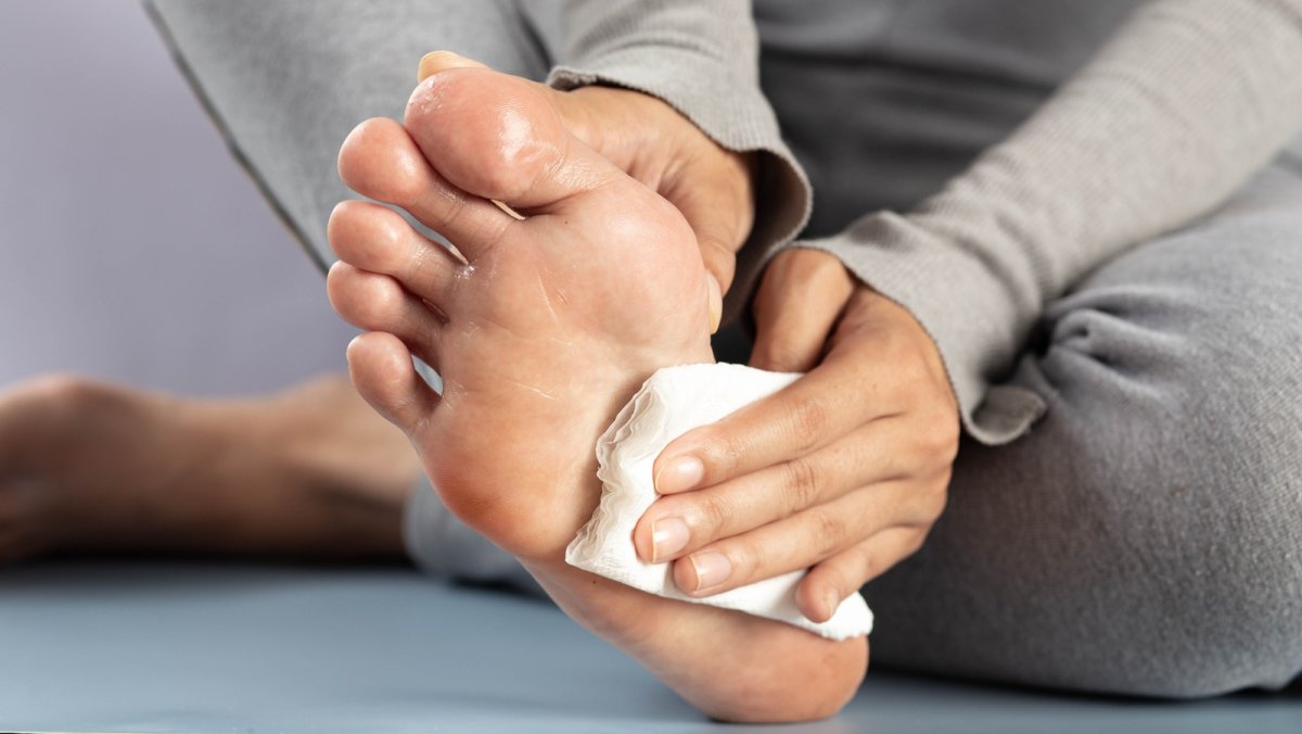 Patting the sole of the foot dry with a cloth — keeping feet dry against sweaty feet